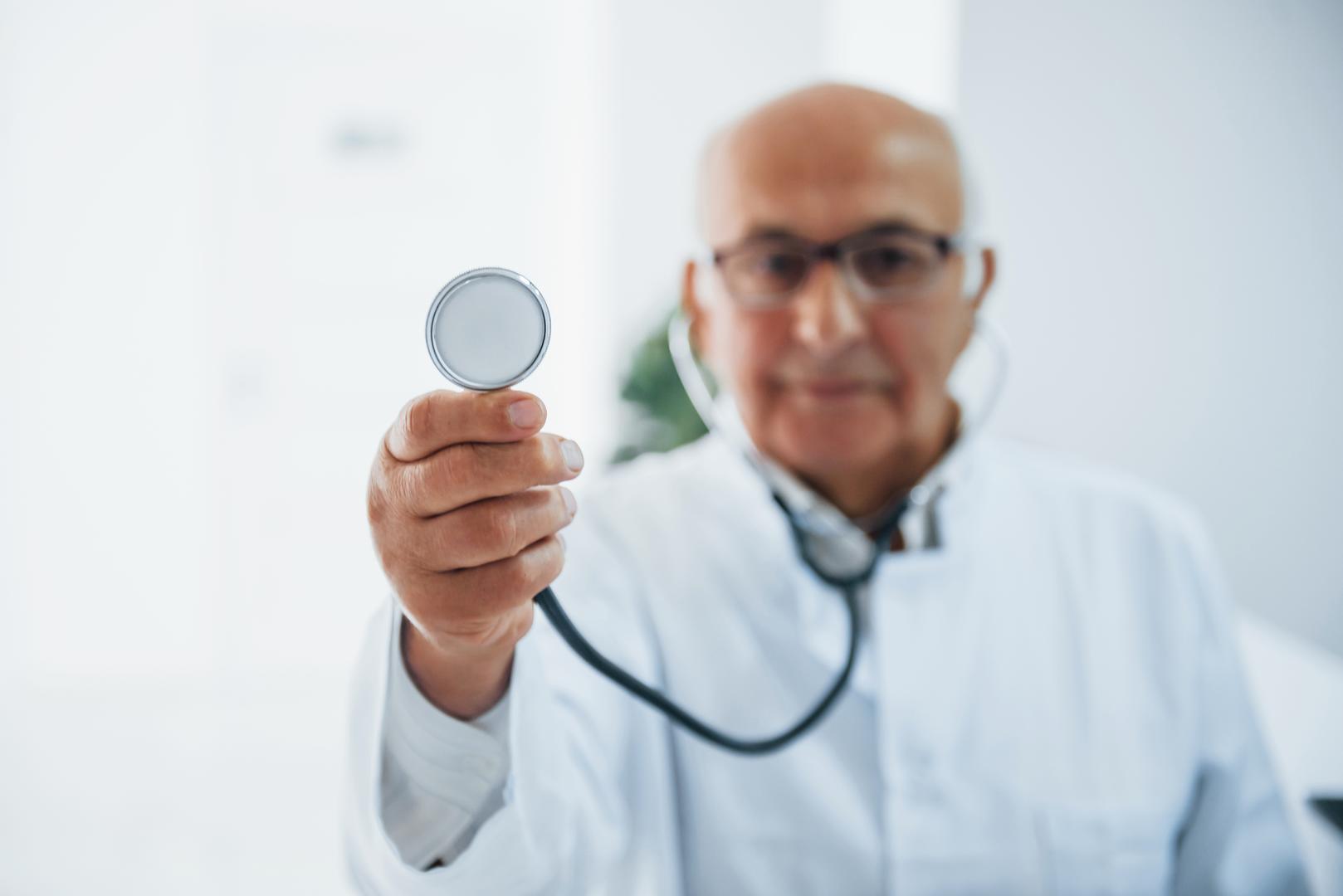 portrait senior doctor with stethoscope white uniform that stands clinic resultado